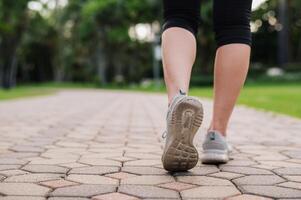 Jogger Frau. schließen oben Person Ausbildung Sport Läufer jung weiblich Schuh auf gehen Pfad im Öffentlichkeit Park. Fitness Bein und Fuß Übung Athlet. Marathon- im Natur. aktiv gesund Lebensstil trainieren Konzept. foto