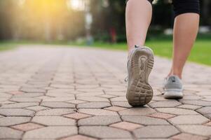 Jogger Frau. schließen oben Person Ausbildung Sport Läufer jung weiblich Schuh auf gehen Pfad im Öffentlichkeit Park. Fitness Bein und Fuß Übung Athlet. Marathon- im Natur. aktiv gesund Lebensstil trainieren Konzept. foto