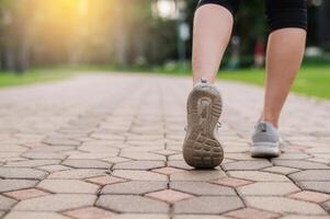 Jogger Frau. schließen oben Person Ausbildung Sport Läufer jung weiblich Schuh auf gehen Pfad im Öffentlichkeit Park. Fitness Bein und Fuß Übung Athlet. Marathon- im Natur. aktiv gesund Lebensstil trainieren Konzept. foto