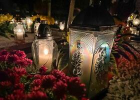 Grab Kerzen auf das Grab während das alle Heilige Tag. Friedhof Kerzen mit schön Beleuchtung und Blumen. Friedhof während das alle Seelen Tag. foto