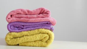 ein Stapel von sauber, gefaltet und farbig Handtücher auf ein Weiß Hintergrund foto