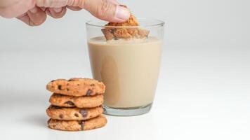 Schokolade Chip Kekse und ein Glas von Milch Kaffee auf ein Weiß Hintergrund foto