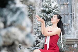 Porträt von Teenager Mädchen im ein rot Kleid entspannt und lächelnd im ein schneebedeckt Hof. foto