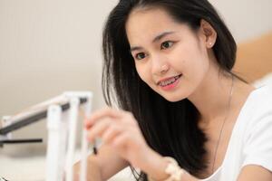 Porträt von Teenager Mädchen Studenten studieren mit Hand Roboter Modell- im das Leben Zimmer foto
