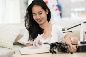 Porträt von Teenager Mädchen Studenten studieren mit Hand Roboter Modell- im das Leben Zimmer foto