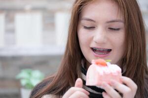 Porträt von Teenager Mädchen Essen ein Stück von Kuchen foto