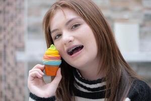 Porträt von Teenager Mädchen Essen ein Stück von Kuchen foto