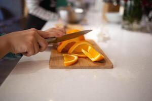 Nahansicht Schuss. Kinder- Hände Schnitt Zitrusfrüchte Früchte zum Herstellung Limonade beim ein kulinarisch Meister Klasse foto