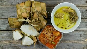 ausgewählt Fokus Ketupat Lebaran, serviert mit Sambal goreng Kentang, opor Ayam und telur semur. traditionell feierlich Speisekarte während eid al-fitr und eid al-adha im Indonesien foto