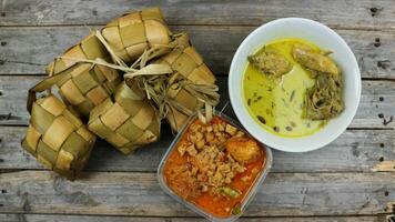 ausgewählt Fokus Ketupat Lebaran, serviert mit Sambal goreng Kentang, opor Ayam und telur semur. traditionell feierlich Speisekarte während eid al-fitr und eid al-adha im Indonesien foto