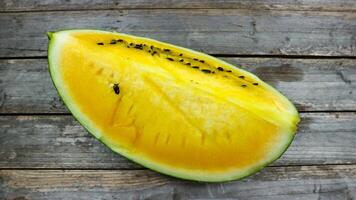 Gelb Wassermelone Scheiben auf hölzern Teller und isoliert auf grau Tafel Hintergrund. gesund Essen, vegan. Antioxidans foto