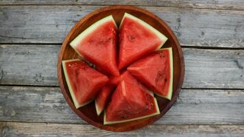 rot Wassermelone Scheiben auf hölzern Teller und isoliert auf grau Tafel Hintergrund. gesund Essen, vegan. Antioxidans foto