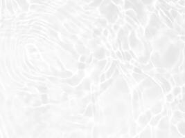 defocus verschwommene, transparente, weiße, klare, ruhige wasseroberflächenstruktur mit spritzern und blasen. trendiger abstrakter naturhintergrund. wasserwellen im sonnenlicht mit kopierraum. weißes Wasser glänzen foto