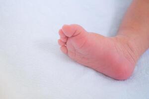 wenig Fuß von Neugeborene Baby auf ein Weiß Decke foto