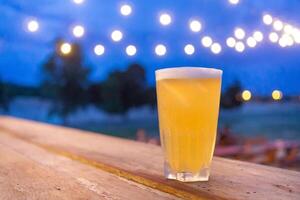 Glas von Bier platziert auf ein hölzern Tabelle foto