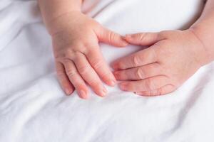 Hände von Neugeborene Baby auf Weiß Stoff foto