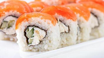 Sushi mit Lachs auf ein Weiß Teller mit Wasabi, Ingwer, Soja, Essstäbchen auf ein Weiß Hintergrund foto