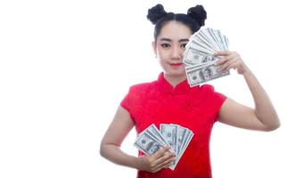 Porträt asiatische Frau rotes Kleid traditionelles Cheongsam hält Geld 100-US-Dollar-Scheine auf weißem Hintergrund