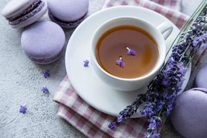 Tasse Tee mit Makronen-Dessert mit Lavendelgeschmack foto