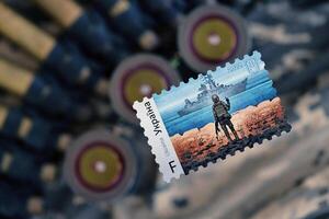 Ternopol, Ukraine - - September 29, 2023 berühmt ukrainisch Stempel mit Russisch Kriegsschiff und ukrainisch Soldat wie hölzern Souvenir auf Heer tarnen Uniform Stoff und Maschine Gewehr Gürtel foto