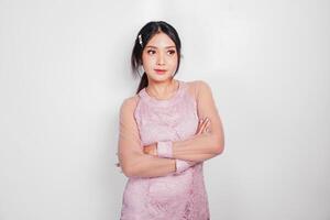 ein attraktiv asiatisch Frau tragen Rosa Kleid ist lächelnd zu das Kamera, isoliert durch Weiß Hintergrund. foto