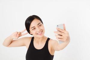 junge asiatische japanische Studentin macht Selfie auf ihrem Handy isoliert auf weißem Hintergrund. studieren oder foto