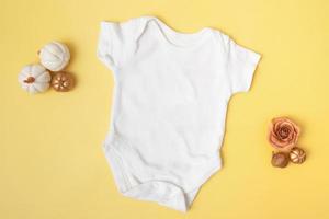Baby-Clobody-Modell mit Kürbissen auf gelbem Hintergrund für Ihren Text- oder Logoplatz in der Herbstsaison foto