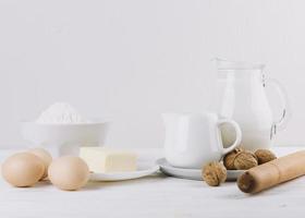 Mehl Milch Eier Käse Nudelholz Walnüsse weißer Hintergrund Kuchen backen