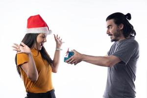 glückliche junge Frau, die Weihnachtsgeschenke von ihrem Mann auf weißem Hintergrund erhält foto