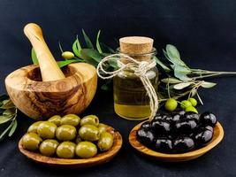 kaltgepresstes Olivenöl mit Zweigen und Früchten