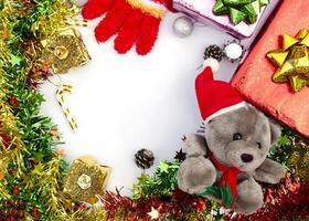 Weihnachtsrahmen mit Teddy und farbigen Tannenzweigen auf weißem Hintergrund oben foto