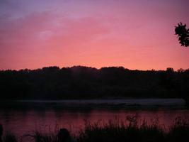 Sonnenuntergang über dem Fluss in natürlicher ländlicher Landschaft foto