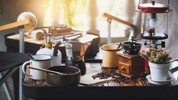 Tasse Kaffee, Bohnenrösten und Zutaten für die Zubereitung von Kaffee und Zubehör auf dem Tisch. Konzept für die Kaffeezubereitung foto