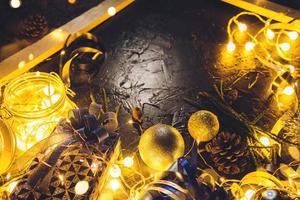 Weihnachtsgeschenk mit blauem Band und Weihnachtsdekorationskugeln auf abstraktem bokeh schwarzem Hintergrund mit Kopienraum und dekorativen LED-Leuchten. frohe weihnachten und neues jahr. foto