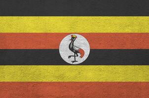 Uganda Flagge abgebildet im hell Farbe Farben auf alt Linderung Verputzen Mauer. texturiert Banner auf Rau Hintergrund foto