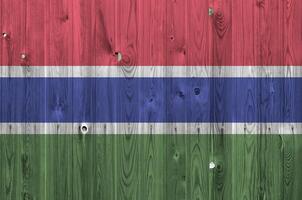 Gambia Flagge abgebildet im hell Farbe Farben auf alt hölzern Mauer. texturiert Banner auf Rau Hintergrund foto