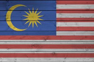 Malaysia Flagge abgebildet im hell Farbe Farben auf alt hölzern Mauer. texturiert Banner auf Rau Hintergrund foto