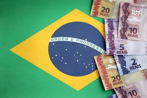 Brasilianer Geld Rechnungen auf oben von das National Flagge von föderativ Republik von Brasilien foto