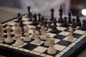 das Schach Tafel mit das Stücke im das dunkel Jahrgang Zimmer foto