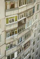 Fassade eines grauen mehrstöckigen sowjetischen Plattengebäudes. russische alte städtische wohnhäuser mit fenstern und balkon. Russische Nachbarschaft foto