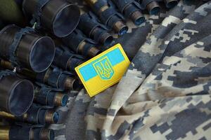 ukrainisch Symbol auf Maschine Gewehr Gürtel Lügen auf ukrainisch pixelig Militär- tarnen foto