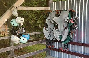 Klettern Ausrüstung - - bunt Helme und Sicherheit Westen hängend auf ein Tafel im ein Seil Park foto