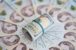 Bündel von hundert uns Dollar Rechnungen Lügen auf viele Banknoten von ukrainisch Griwna. wirtschaftlich Standard, Krise und Abwertung von ukrainisch National Währung foto