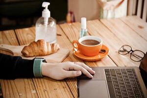 Frauen mit Laptop Arbeiten und sauber Hände mit Alkohol trinken Kaffee Tasse heiß beim Zuhause foto