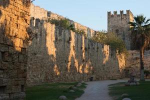 Rhodos Stadtbefestigung. alter Steinturm und Palme bei Sonnenuntergang. schönes Wahrzeichen. Dodekanes, Griechenland. foto