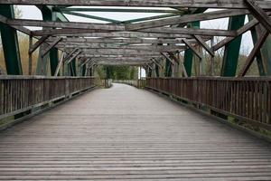 Überqueren einer Holzbrücke mit Metallstruktur foto