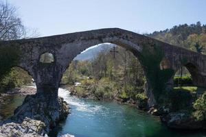 Römische Brücke von Cangas de Onis, Asturien, über den Fluss Sella, ohne Menschen. Siegeskreuz hängt von der Brücke foto