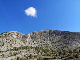 einzelne Wolke über dem Berg foto