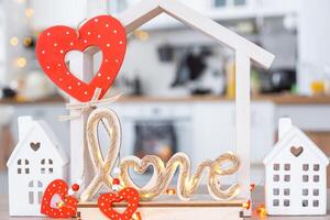 Schlüssel zu winzig Haus von gemütlich Zuhause mit Valentinstag Dekor auf Tabelle von Küche. Geschenk zum Valentinsgrüße Tag, Familie Liebe Nest. Design, Projekt, ziehen um zu Neu Haus, Hypothek, Miete und Kauf echt Nachlass foto