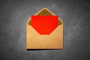 Briefumschlag mit rot Papier Innerhalb auf grau Hintergrund. foto